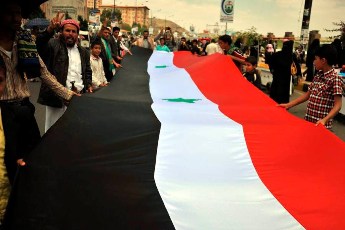 Manifestantes antigubernamentales portan una enorme bandera siria durante protesta. (Foto: EFE / VANGUARDIA LIBERAL)