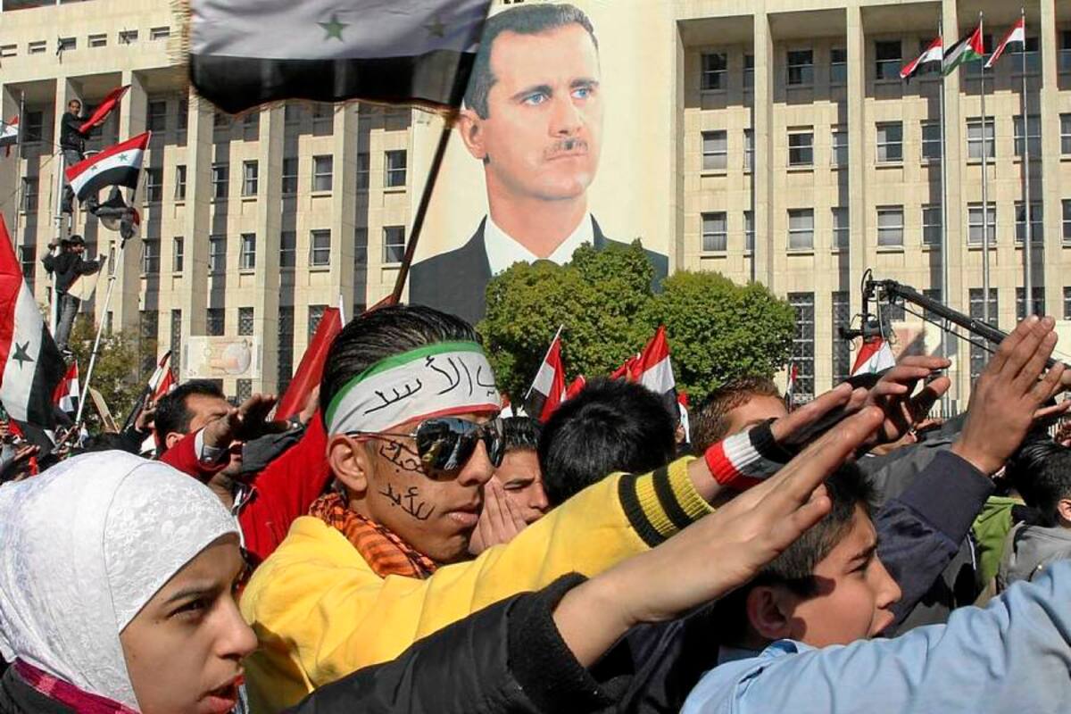 Manifestantes sirios cantan el himno nacional ante una fotografía gigante del presidente Bashar Assad durante una manifestación de apoyo al gobierno. (Foto: EFE / VANGUARDIA LIBERAL)