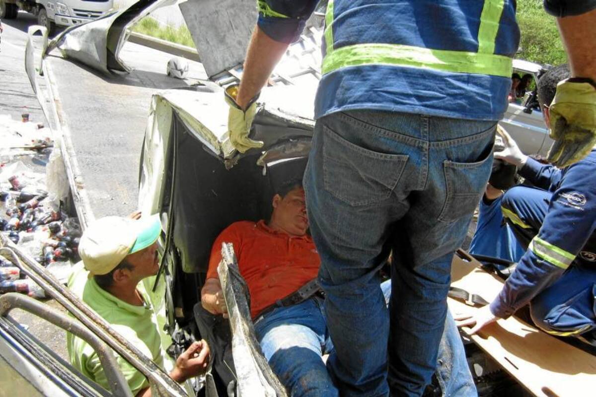 Este es el momento en el que uno de los ocupantes del camión es rescatado. La cabina quedó destruida. (Foto: Suministrada/VANGUARDIA LIBERAL )
