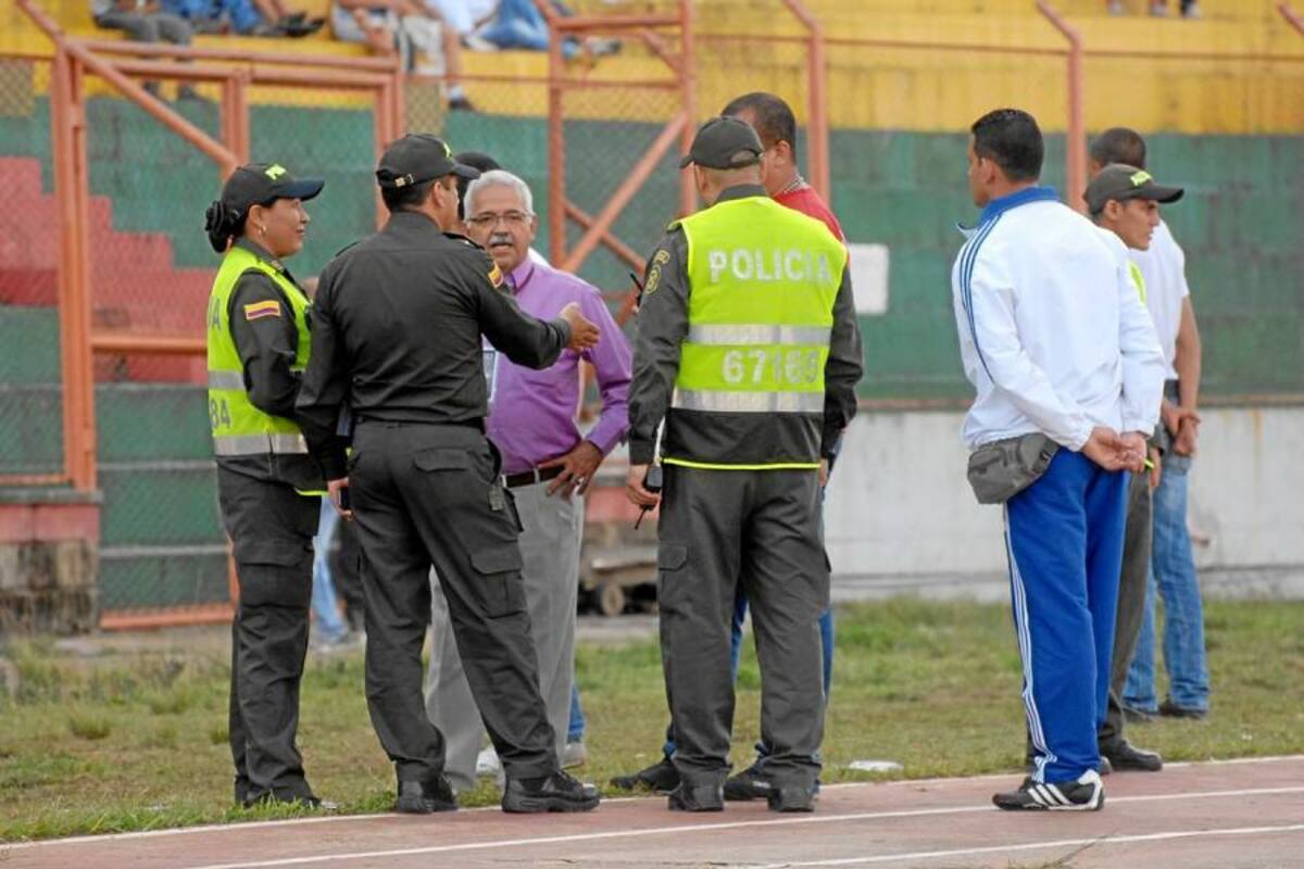 Seguridad ante todo. En medio del partido varios miembros de la Policía Metropolitana de Bucaramanga se reunieron en plena pista atlética del Alfonso López con personal de logística del estadio para discutir los pasos a seguir para evacuar a las dos barras del América que llegaron a la tribuna norte del escenario deportivo. (Foto: Jaime del Río / VANGUARDIA LIBERAL)