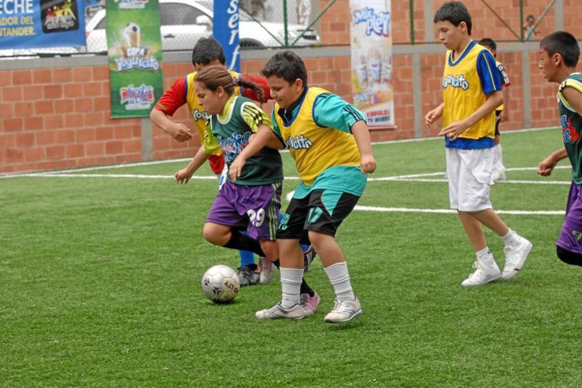 Haciendo gala de un gran dominio de balón y una gran condición técnica, Camila Fuentes fue la gran figura de la eliminatoria de la Copa Yogurcito Freskaleche de Futbolito, que se realizó ayer en las canchas sintéticas de Futbolmanía, en la gráfica se ve como elude a sus rivales, que son más grandes y fuertes que ella. (Foto: Jaime del Río / VANGUARDIA LIBERAL)