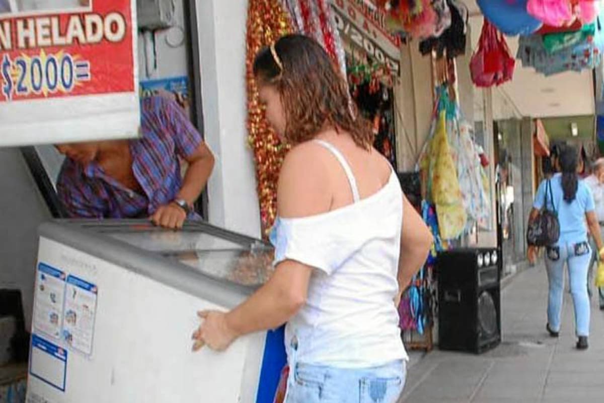 Algunos vendedores sacan sus enfriadores a la acera para expender sus productos y con esto restringen el espacio a los transeúntes. (Foto: Edgar Pernett/VANGUARDIA LIBERAL)
