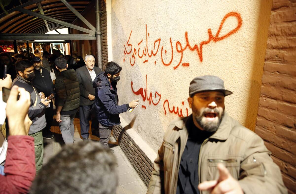 Tehran (Iran(islamic Republic Of)), 17/10/2023.- Iranian students write anti-Israel and France sentences on the wall of the French embassy as hundreds of Pro-Palestine supporters gathered to show their solidarity with Gaza people in front of the French embassy after Gaza hospital strike, in Tehran, Iran, early 18 October 2023. The protest erupted hours after Hamas-led authorities in Gaza said hundreds of people have been killed in an Israeli strike on a hospital in Gaza on 17 October. According to the Israel Defense Forces (IDF), the Islamic Jihad is responsible for the failed rocket launch that hit the hospital. (Protestas, Francia, Teherán) EFE/EPA/ABEDIN TAHERKENAREH