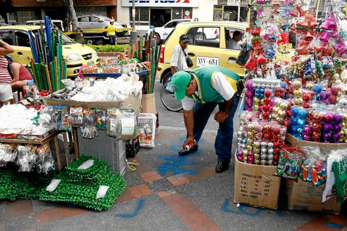 A punta de aerosol, los inspectores del espacio público les indican a los vendedores informales qué tanto pueden invadir los andenes. ¡Qué tal! (Foto: Marcos Valencia/ VANGUARDIA LIBERAL)