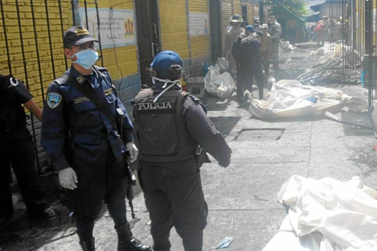 Policías realizan el levantamiento de algunos de los cadáveres causados por un incendio en la Granja Penal de Comayagua (Foto: EFE / VANGUARDIA LIBERAL )