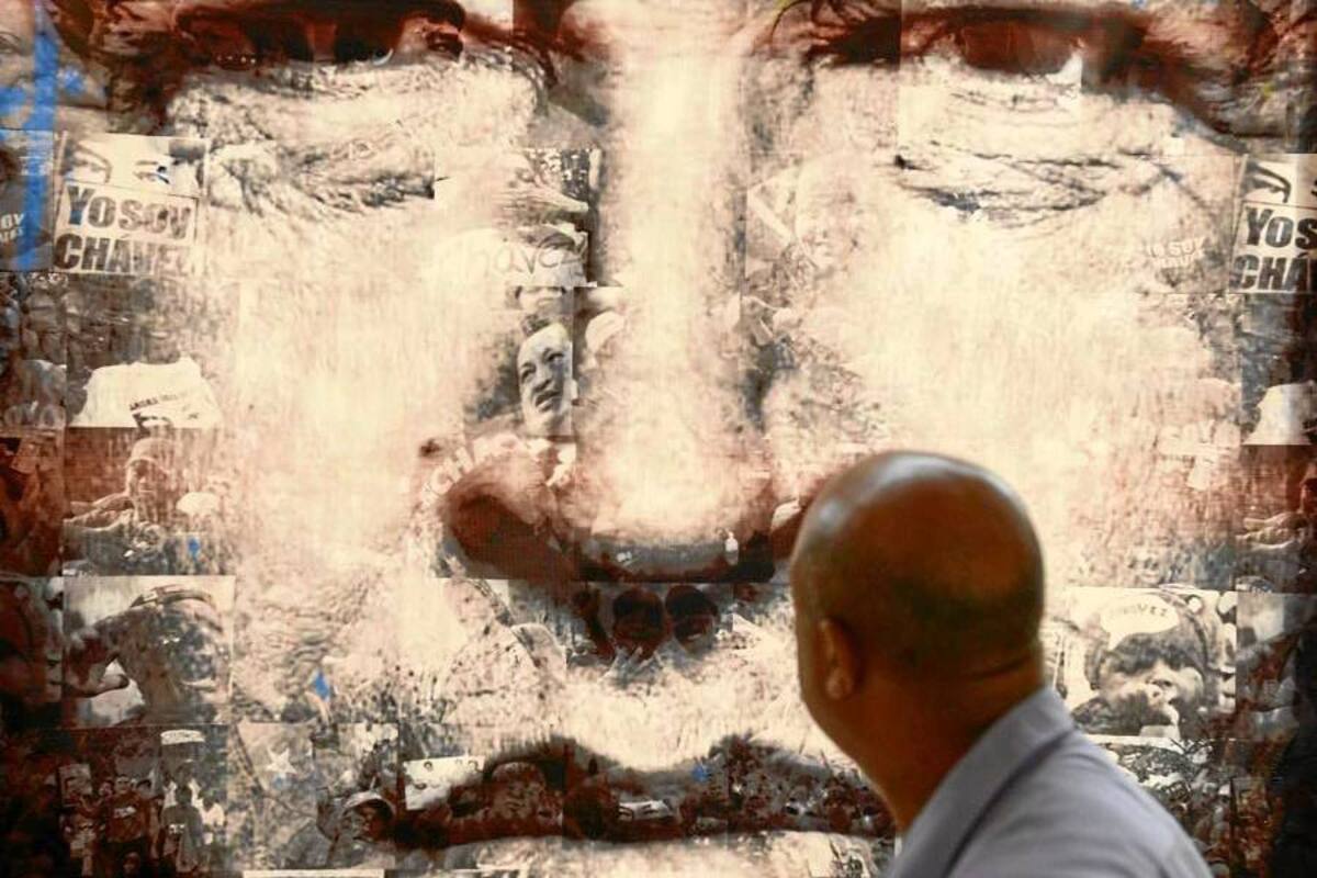 Un hombre observaba ayer un gran afiche con la imagen del fallecido mandatario Hugo Chávez, cuyos restos reposan en el Cuartel de la Montaña en el barrio 23 de Enero de Caracas. (Foto: AFP / VANGUARDIA LIBERAL)