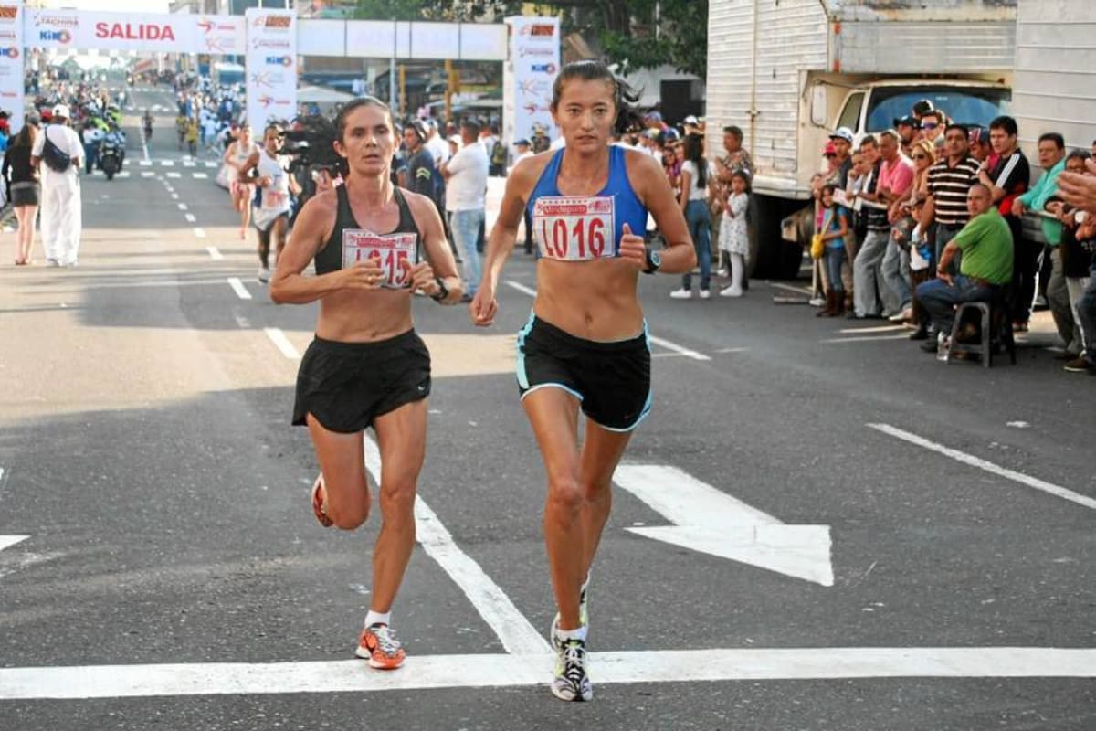 Esta imagen muestra a las dos atletas santandereanas, Ana Joaquina Rondón (izquierda) y Lineida Mateus (derecha), cruzando la línea de meta para salir a dar la segunda vuelta de la Media Maratón de San Sebastián corrida el pasado domingo en San Cristóbal, Venezuela. (Foto: Tomada de Internet / VANGUARDIA LIBERAL)