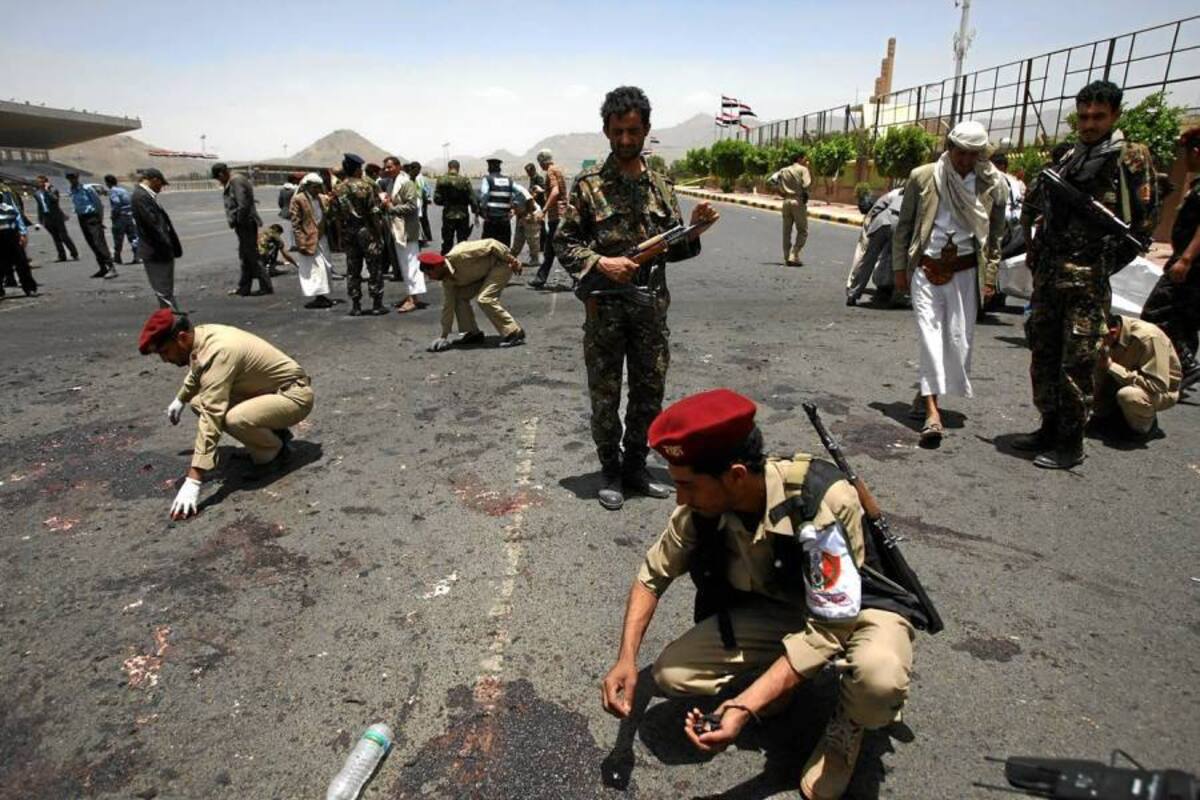 Expertos militares recolectan evidencia en el sitio donde el suicida activó la bomba en la plaza Al Sabin, cerca del Palacio Presidencial de la capital yemení. (Foto: AFP / VANGUARDIA LIBERAL )