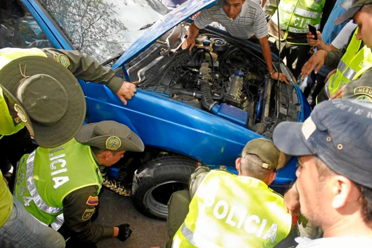 Como la boa se escondió en el amortiguador, los miembros de la Policía Ambiental la tuvieron que sacar por debajo del vehículo. (Foto: Nelson Díaz / VANGUARDIA LIBERAL)
