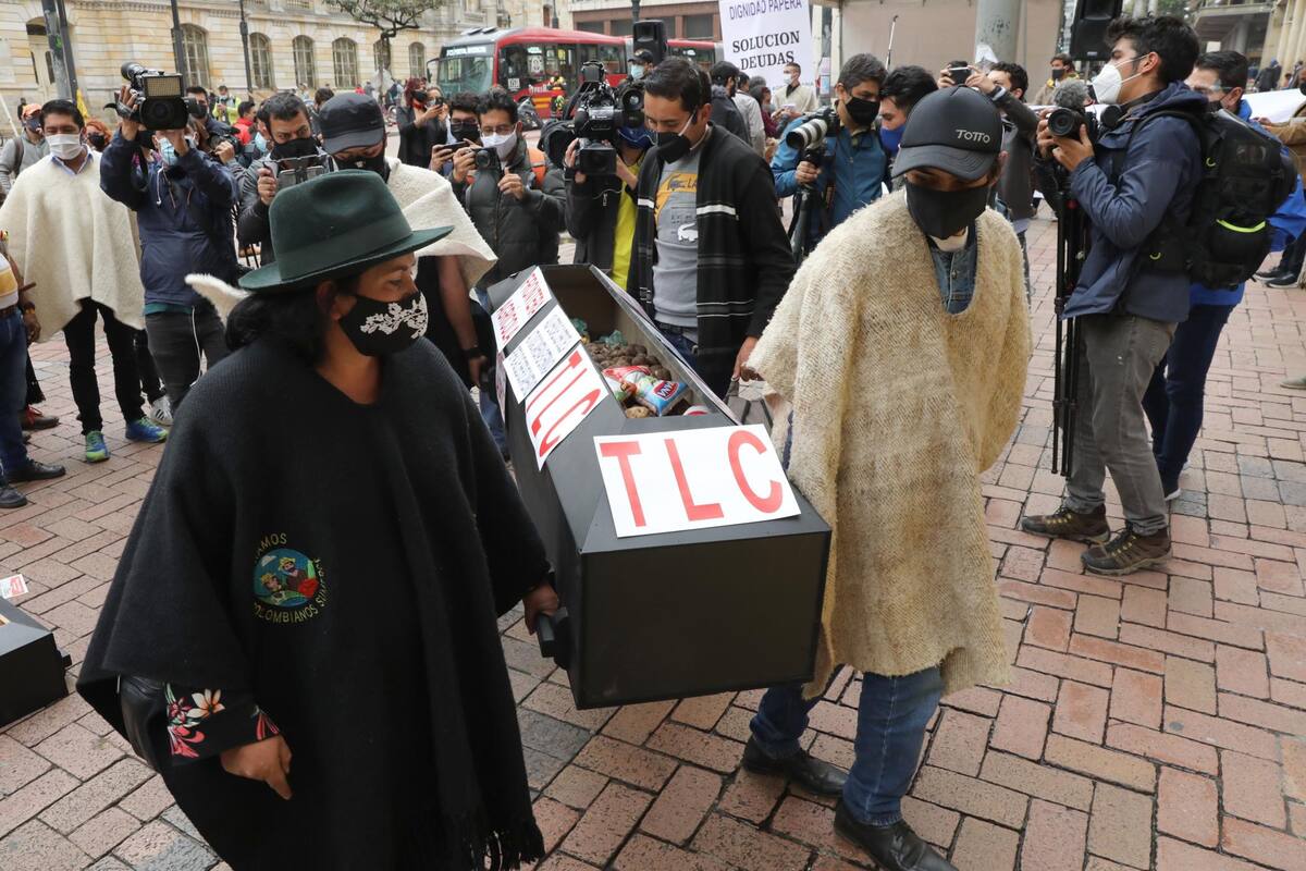Un grupo de campesinos carga ataúd este viernes frente al ministerio de Agricultura durante una protesta en Bogotá.