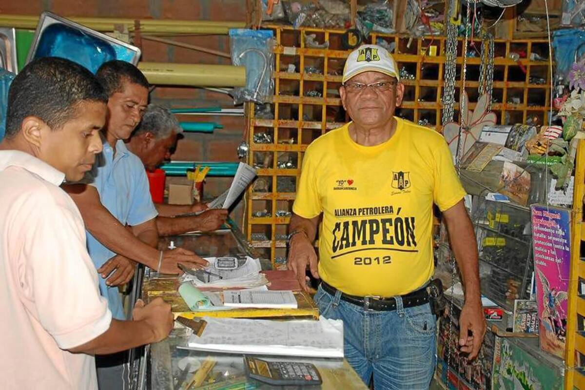 Mientras atiende a la clientela de su ferretería, Emilio Rafael Vanegas Rendón, conocido popularmente como ‘Alianza’, no deja que la conversación sea diferente que la final que mañana miércoles jugará Alianza Petrolera contra América de Cali. (Foto: Edgar Pernett/VANGUARDIA LIBERAL)