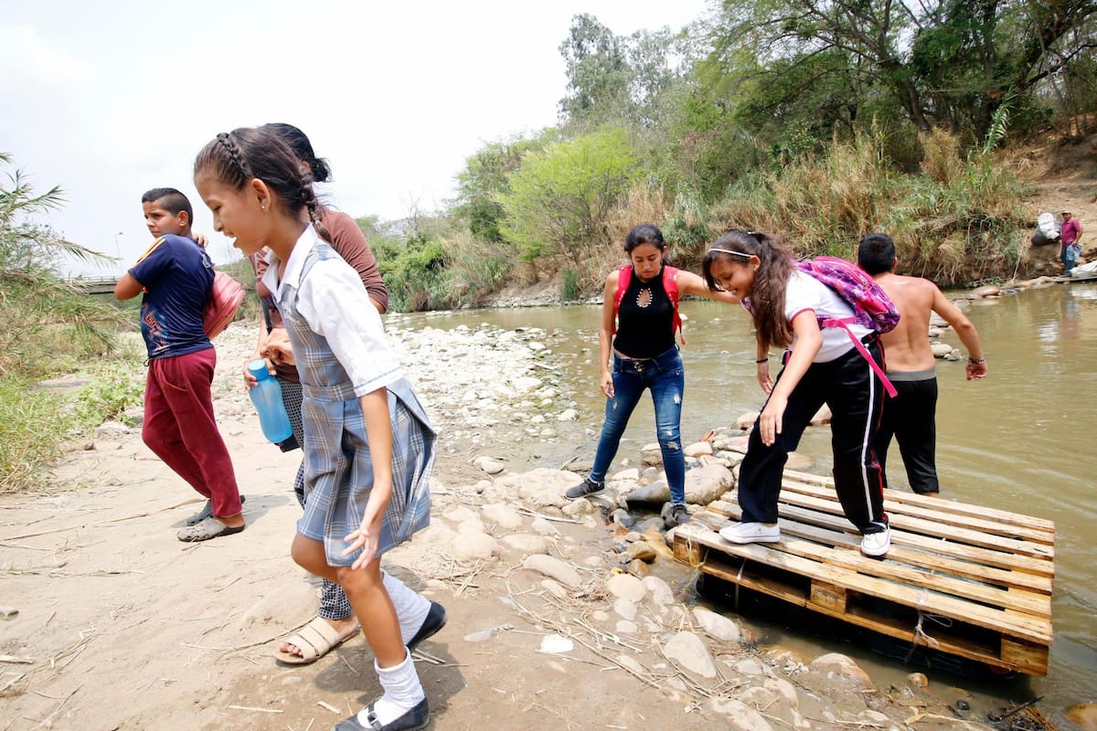 Estudiantes venezolanos cruzan hacía Colombia por el río debido al cierre de los pasos fronterizos en Cúcuta. EFE/SCHNEYDER MENDOZA