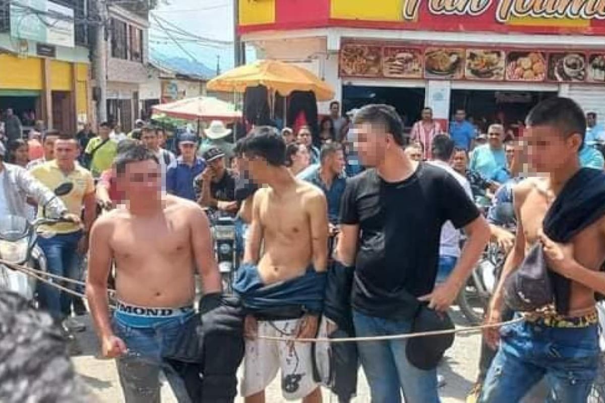 Los detenidos que lograron salir ilesos fueron obligados por la comunidad a cargar el cuerpo sin vida del joven que recibió el disparo. FOTO: CAPTURA DE PANTALLA.
