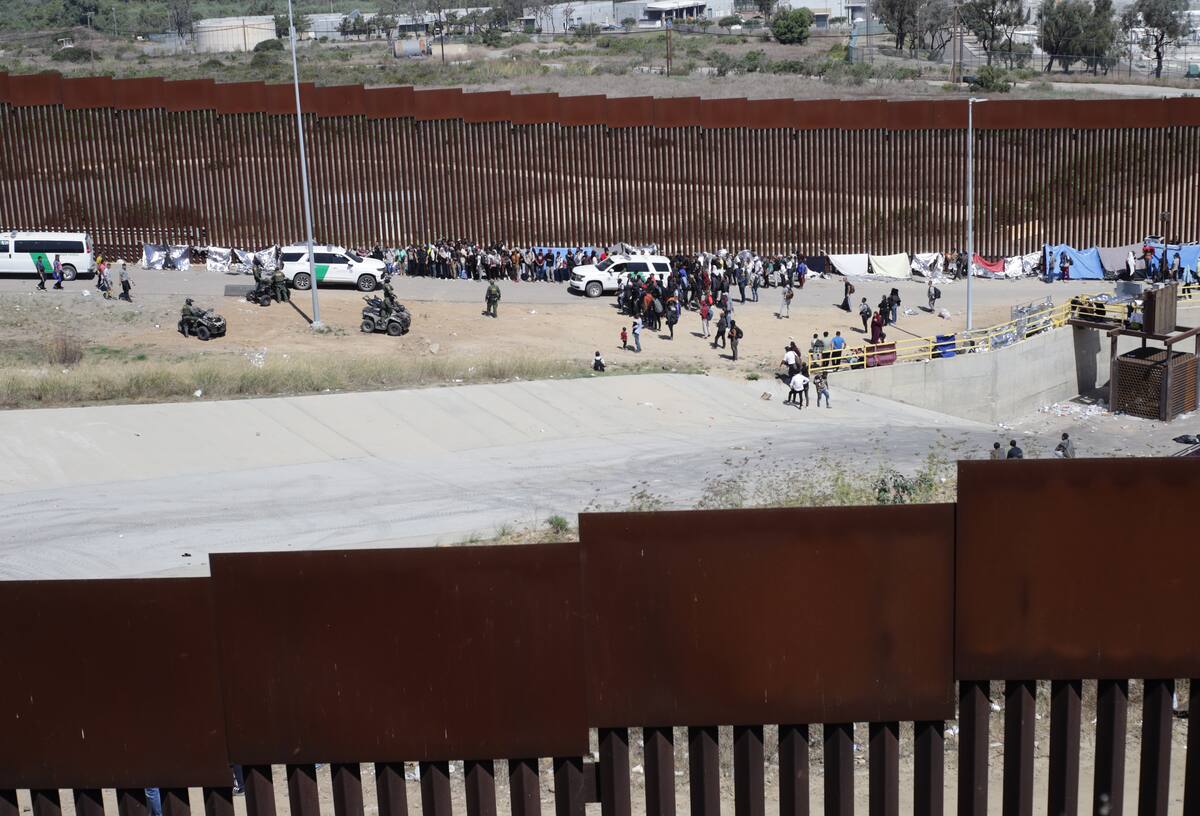 Migrantes de diversas nacionalidades acampan junto al muro fronterizo estadounidense. Archivo EFE/VANGUARDIA