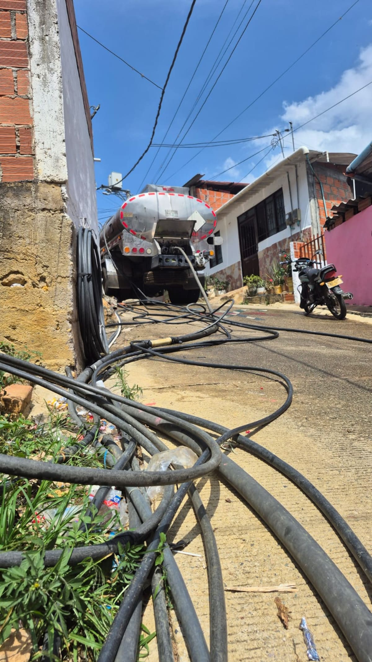 El carrotanque que abastece de agua al barrio San Martín y Los Santos, así como la maraña de mangueras que hay en este sector. (Juan Carlos Chio / VANGUARDIA)