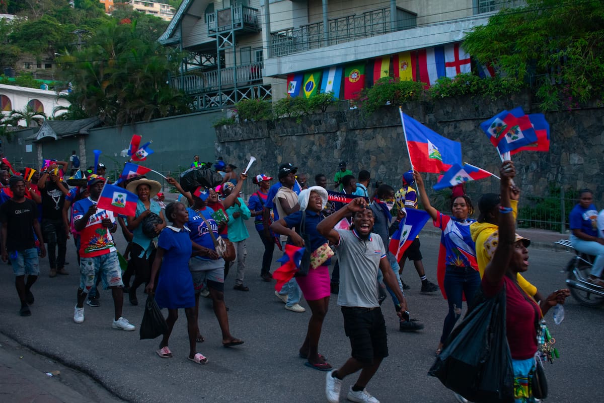 AME2555. PUERTO PRÍNCIPE (HAITÍ), 20/06/2026.- Aficionados de Haití sostienen banderas previo a la transmisión del partido del Mundial de la FIFA 2026 contra Brasil este viernes, en la Plaza Boyer, en Puerto Príncipe (Haití). EFE/ Jonet St Élois