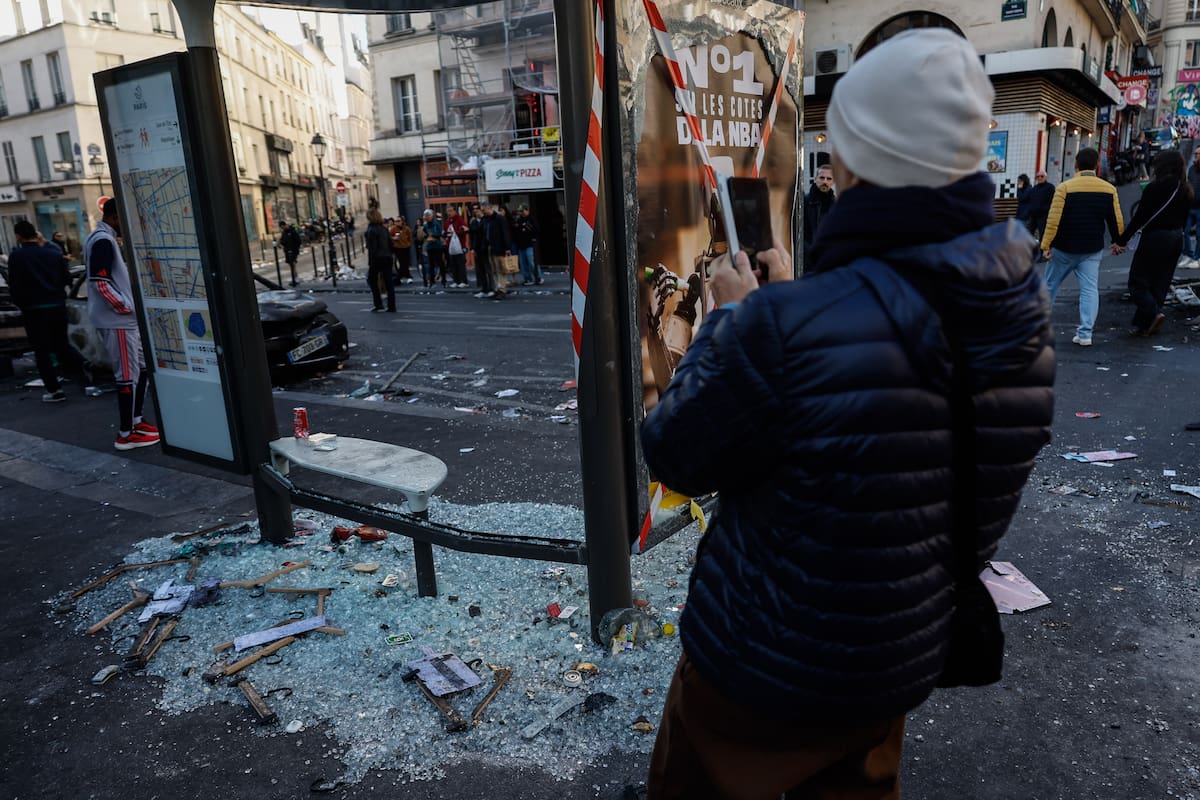 Paris (France), 18/10/2026.- A man takes a photograph of damages in the aftermath of clashes between riot police and demonstrators during nationwide protests against the high cost of living in the country, in Paris, France, 18 October 2026. (Protestas, Francia) EFE/EPA/MOHAMMED BADRA