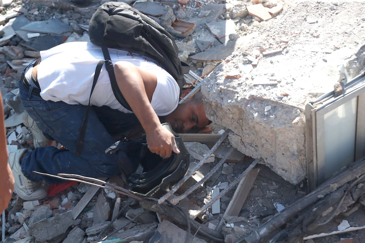 AME7645. CALI (COLOMBIA), 10/08/2026.- Una persona busca en los escombros de un edificio colapsado este lunes, en Cali (Colombia). Al menos 20 edificios sufrieron graves daños por consecuencia del terremoto de magnitud 7,4 que sacudió la mayor parte del país, con epicentro en la zona del Pacífico. EFE/ Ernesto Guzmán