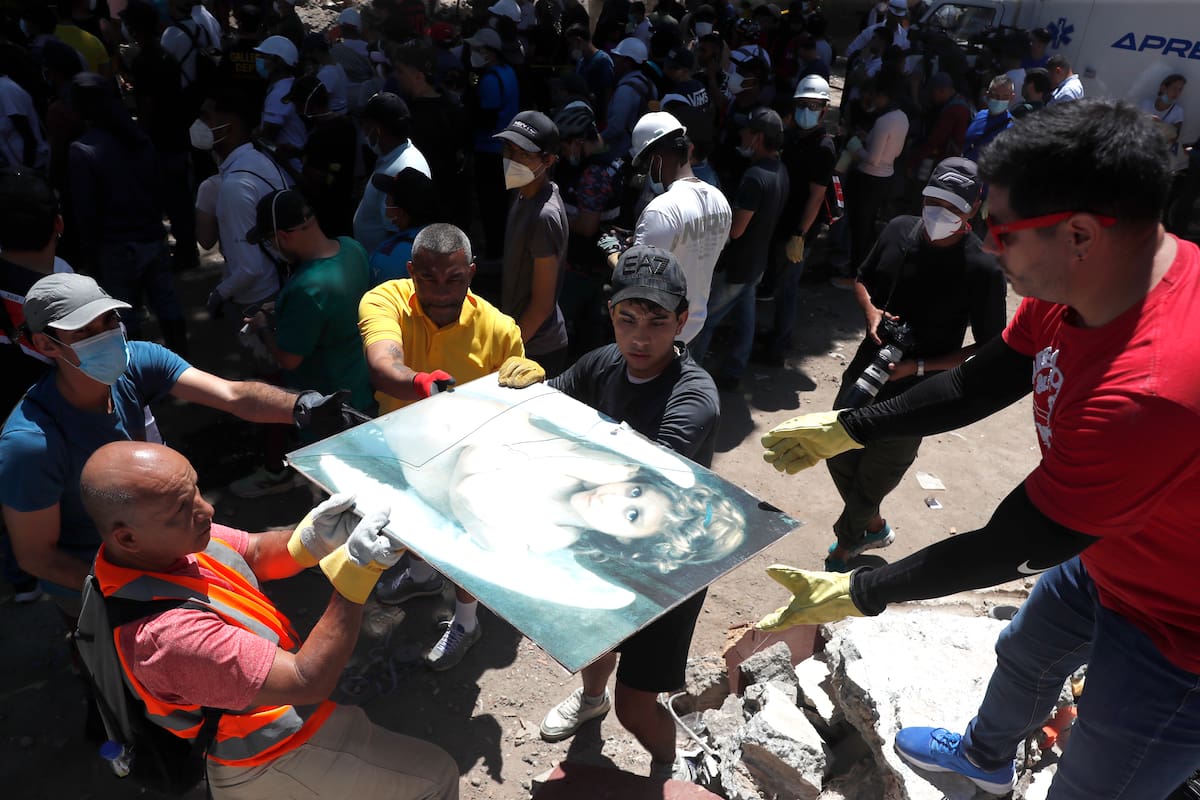 AME8030. CALI (COLOMBIA), 11/08/2026.- Socorristas y voluntarios sostienen un cuadro durante una jornada de búsqueda, entre los escombros de una edificación tras el terremoto de magnitud 7,4 que sacudió el lunes al país, este martes en Cali (Colombia). Al menos 240 personas murieron en cuatro regiones de Colombia por el terremoto, según el balance de distintas autoridades regionales ante la demora del Gobierno nacional en actualizar las cifras. EFE/ Ernesto Guzmán