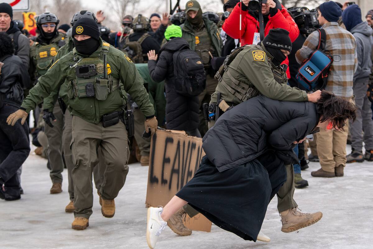 Un integrante de la Policía detiene a una persona durante las protestas frente al edificio Federal Bishop Henry este jueves, en Mineápolis (EE.UU.). Al menos ocho personas fueron detenidas este jueves durante el inicio de la segunda jornada de protestas por la muerte de una mujer estadounidense tras recibir varios disparos por parte de un agente del Servicio de Inmigración y Control de Aduanas (ICE), confirmaron testigos a EFE. EFE/ Angel Colmenares
