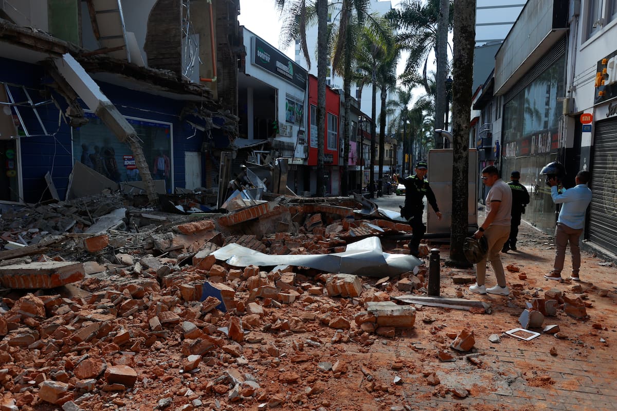 AME7622. MANIZALES (COLOMBIA), 10/08/2026.- Personas caminan frente a una edificación afectada tras un fuerte temblor este lunes, en Manizales (Colombia). Al menos dos personas murieron en la capital del departamento de Caldas, por el terremoto de magnitud 7,4 que sacudió buena parte del territorio nacional, según informó el alcalde de esa ciudad, Jorge Eduardo Rojas Giraldo. EFE/ John Jairo Bonilla