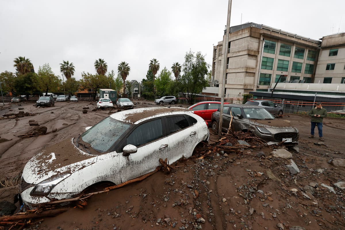Fotografía que muestra vehículos afectados por el paso del aluvión en la comuna de Las Condes este viernes, en Santiago (Chile). Un aluvión por intensas lluvias que afectó a la comuna Las Condes, en el este de Santiago, y generó el arrastre de vehículos y buses en las calles, dejó 6 personas lesionadas y 600 hogares evacuados, informó el ministro del Interior de Chile, Claudio Alvarado. EFE/ Elvis González
