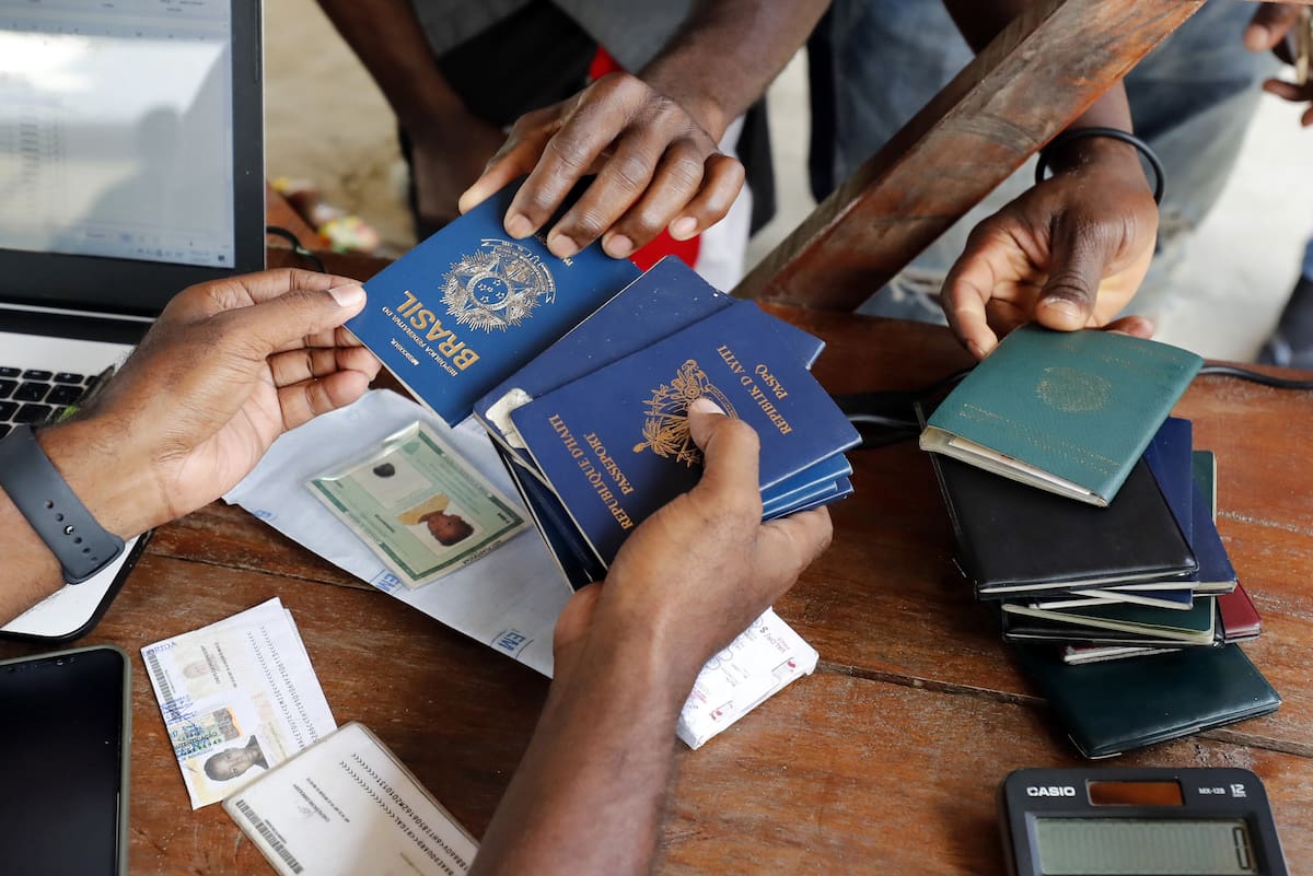 AME5069. NECOCLÍ (COLOMBIA), 19/06/2024.- Fotografía de archivo fechada el 3 de mayo de 2021 de una persona mientras recibe pasaportes de migrantes de diversas partes del mundo que compran tiquetes para Capurganá, en el embarcadero de Necoclí (Colombia). En América Latina y el Caribe hay 23 millones de personas refugiadas, desplazadas internas o apátridas como consecuencia de seis grandes crisis humanitarias que ponen a la región en una emergencia sin precedentes, según cifras divulgadas por ACNUR en vísperas del Día Mundial del Refugiado. EFE/ Mauricio Duenas Castañeda ARCHIVO