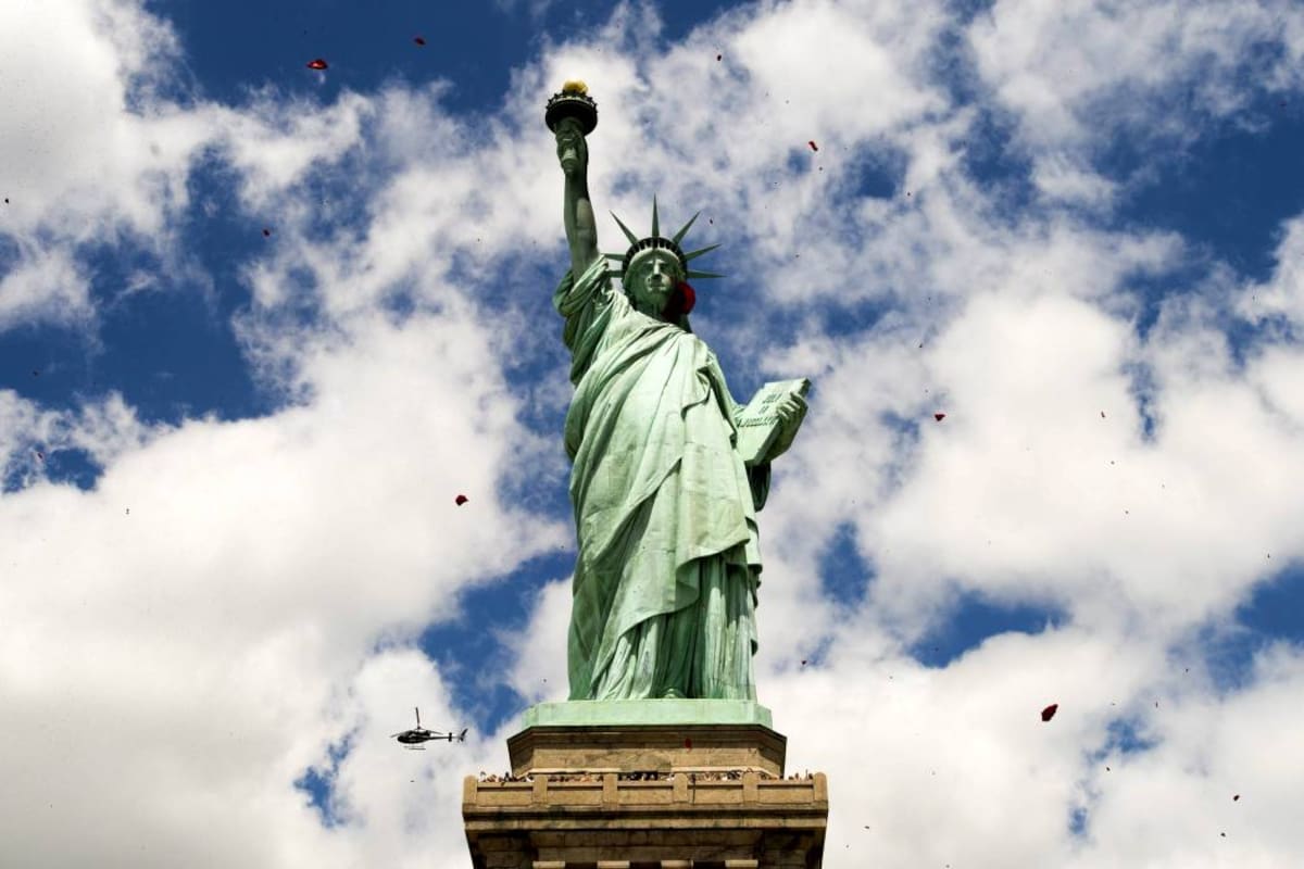 JLX04 NUEVA YORK (ESTADOS UNIDOS), 06/06/2014.- Pétalos de rosa caen junto a la Estatua de la Libertad por el 70 aniversario del desembarco de Normandía en la ciudad de Nueva York, Estados Unidos hoy 6 de junio de 2014. EFE/Justin Lane