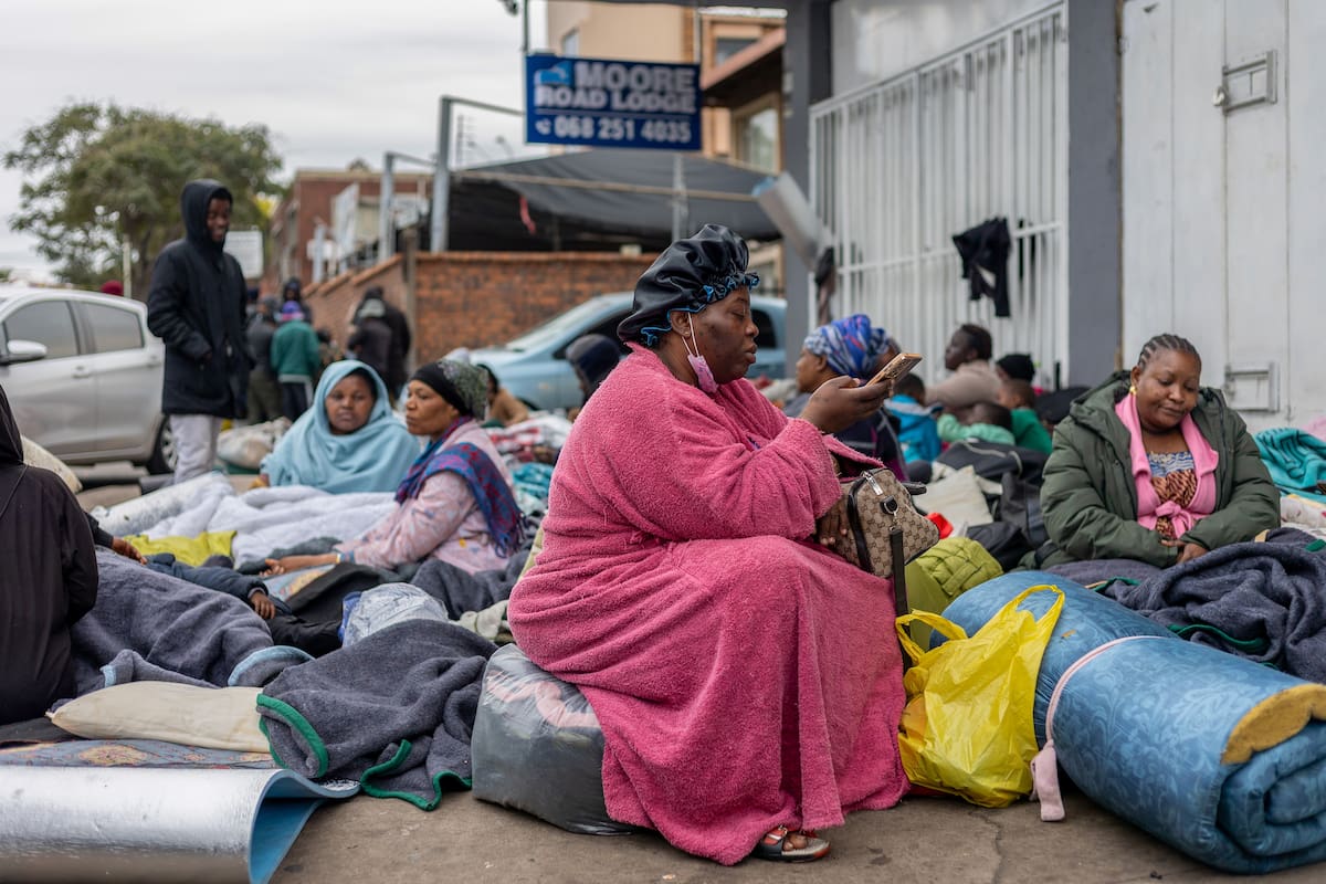 DURBAN (South Africa), 30/06/2026.- Migrant workers shelter outside a Home Affairs building during a nationwide anti-immigrant movement shutdown in Durban, South Africa, 30 June 2026. Marches are planned across South Africa as a large number of organizations under the umbrella of the 'March and March movement' take to the streets of major cities to protest against the high number of legal and illegal immigrants living in the country. Although the protesters issued an ultimatum demanding that foreign nationals leave South Africa by 30 June, the South African government has explicitly rejected the shutdown and declared June 30 a normal working day. (Protestas, Sudáfrica) EFE/EPA/STRINGER