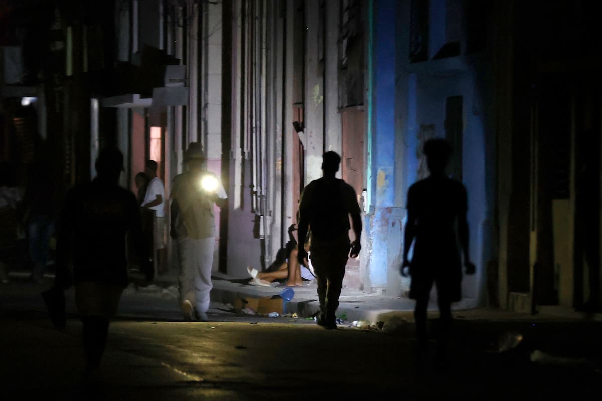 Personas caminando por una calle durante un apagón en La Habana (Cuba). //EFE - Ernesto Mastrascusa.