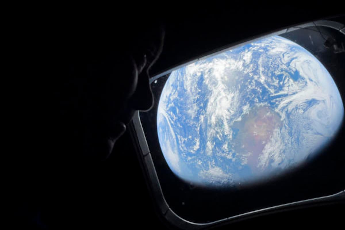 El comandante Reid Wiseman observa la Tierra mientras continúan adentrándose en el espacio hacia la Luna. EFE/ NASA