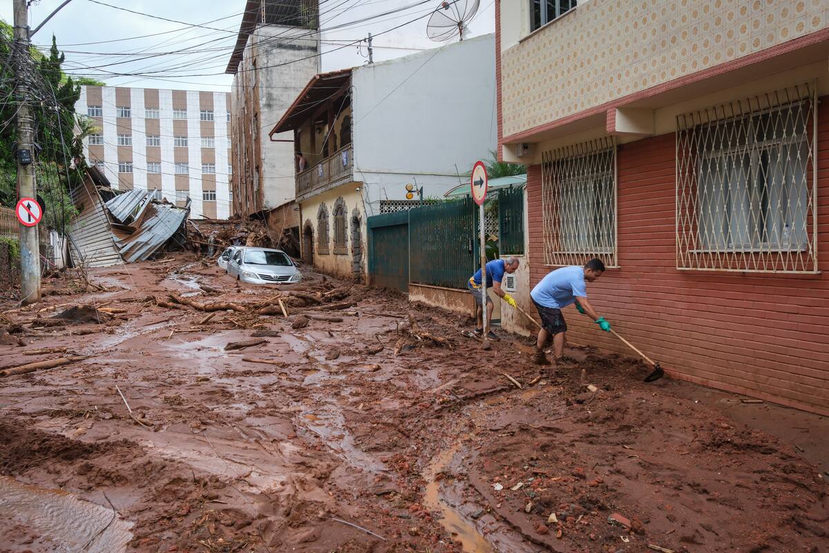 AME8302. JUIZ DE FORA (BRASIL), 25/02/2026.- Personas remueven escombros de una zona afectada por fuertes lluvias este miércoles, en Juiz de Fora (Brasil). El número de víctimas mortales causado por las lluvias que azotan el sureste de Brasil aumentó a 36 en el estado de Minas Gerais, mientras que los equipos de rescate buscan a 33 desaparecidos, informaron fuentes oficiales.EFE/ Andre Coelho
