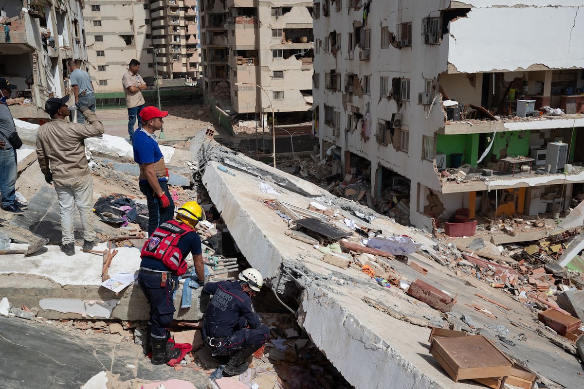 AME4835. CATIA LA MAR (VENEZUELA), 26/06/2026.- Personas realizan labores de búsqueda y remoción de escombros en edificios afectados por terremotos este jueves, en Catia La Mar (Venezuela). El presidente del Parlamento de Venezuela, el chavista Jorge Rodríguez, informó que los fallecidos por los dos terremotos ocurridos el miércoles en su país ya dejan 920 muertos y 3.360. EFE/ Ronald Peña R