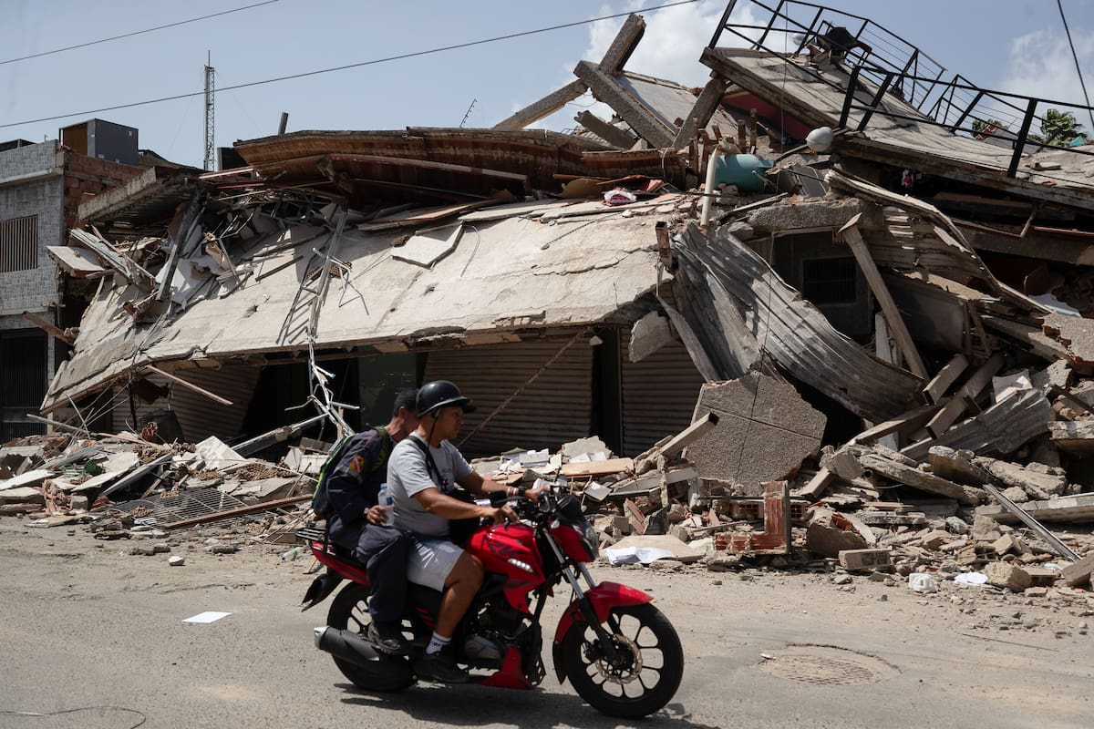 AME4836. CATIA LA MAR (VENEZUELA), 26/06/2026.- Personas transitan frente a edificios afectados por terremotos este jueves, en Catia La Mar (Venezuela). El presidente del Parlamento de Venezuela, el chavista Jorge Rodríguez, informó que los fallecidos por los dos terremotos ocurridos el miércoles en su país ya dejan 920 muertos y 3.360. EFE/ Ronald Peña R