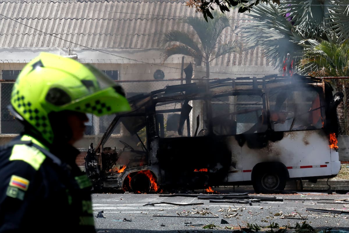 Un integrante de la Policía de Colombia camina frente a un vehículo afectado por una explosión este viernes, en inmediaciones del batallón de la Tercera Brigada del Ejército en Cali (Colombia). EFE/ Ernesto Guzman Jr