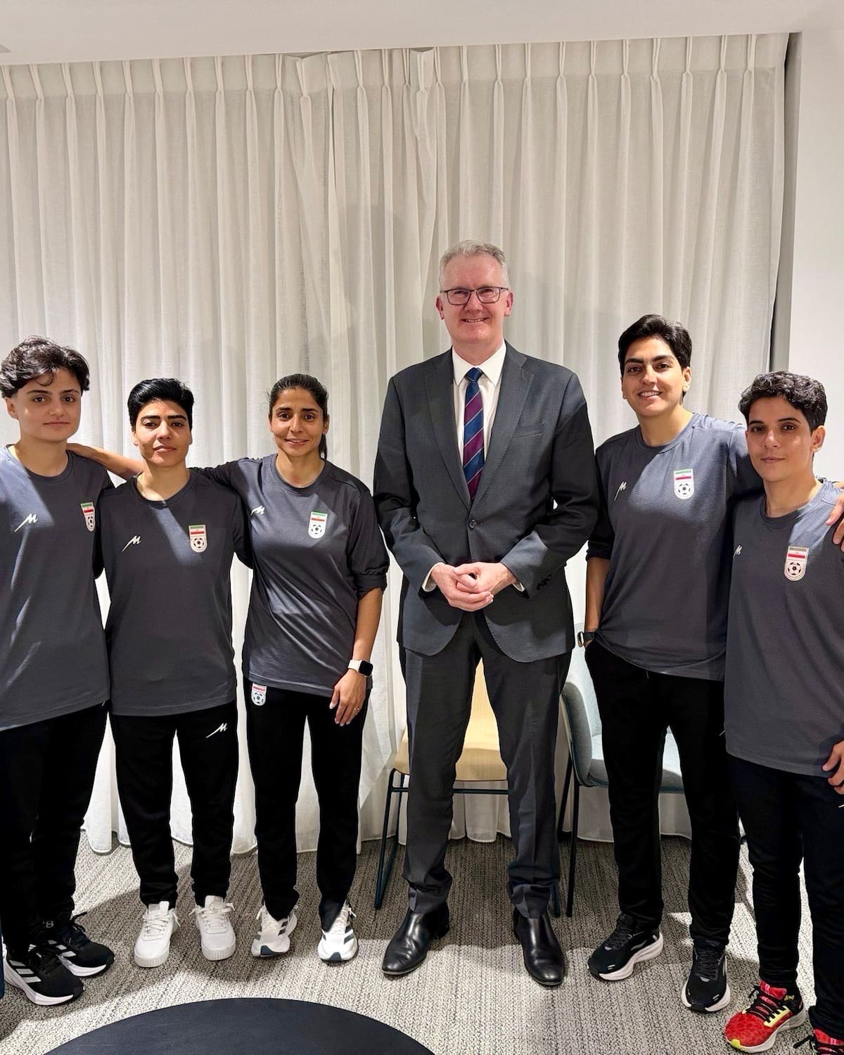 AME2524. SIDNEY (AUSTRALIA), 09/03/2026.- Fotografía tomada de la cuenta de la red social X @Tony_Burke del ministro del Interior de Australia, Tony Burke (c), posando junto a cinco futbolistas de la selección femenina de fútbol de Irán, quienes permanecerán en Australia tras recibir visados humanitarios concedidos por el Gobierno australiano, después de solicitar asistencia para no regresar a su país tras su participación en la Copa de Asia. EFE/ @Tony_Burke /SOLO USO EDITORIAL/NO VENTAS/ SOLO DISPONIBLE PARA ILUSTRAR LA NOTICIA QUE ACOMPAÑA (CRÉDITO OBLIGATORIO)
