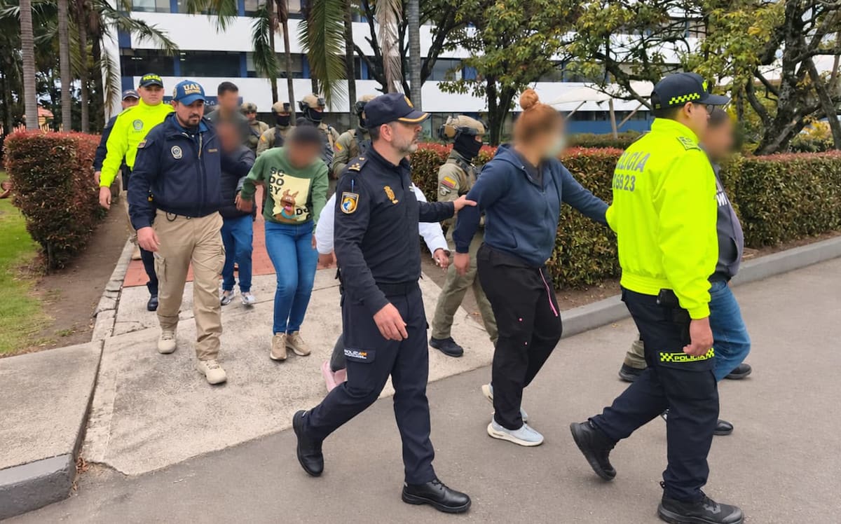 AME1446. BOGOTÁ (COLOMBIA), 29/09/2026.- Fotografía cedida por la oficina de prensa de la DIJIN e INTERPOL que muestra el traslado de 15 personas capturadas, entre ellas cuatro funcionarios públicos, por su presunta participación en una red transnacional que vendía documentos de identidad colombianos a extranjeros para facilitar su viaje a Estados Unidos y Europa, este martes en Bogotá (Colombia). EFE/ DIJIN INTERPOL /SOLO USO EDITORIAL/ NO VENTAS/ SOLO DISPONIBLE PARA ILUSTRAR LA NOTICIA QUE ACOMPAÑA (CRÉDITO OBLIGATORIO)