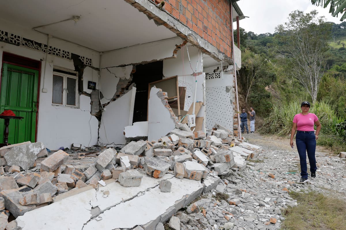 ACOMPAÑA CRÓNICA: COLOMBIA TERREMOTO AME9646. ANSERMANUEVO (COLOMBIA), 16/08/2026.- Johanna Castañeda camina este sábado frente a su casa afectada por el terremoto de magnitud 7,4 del pasado lunes, en Ansermanuevo (Colombia). Una bandera blanca con el mensaje Ayuda, SOS, colgada en una vivienda rural de Ansermanuevo, evidencia la angustia de los campesinos afectados por el terremoto, quienes claman por ayuda ante el riesgo de que sus casas se derrumben. EFE/ Carlos Ortega