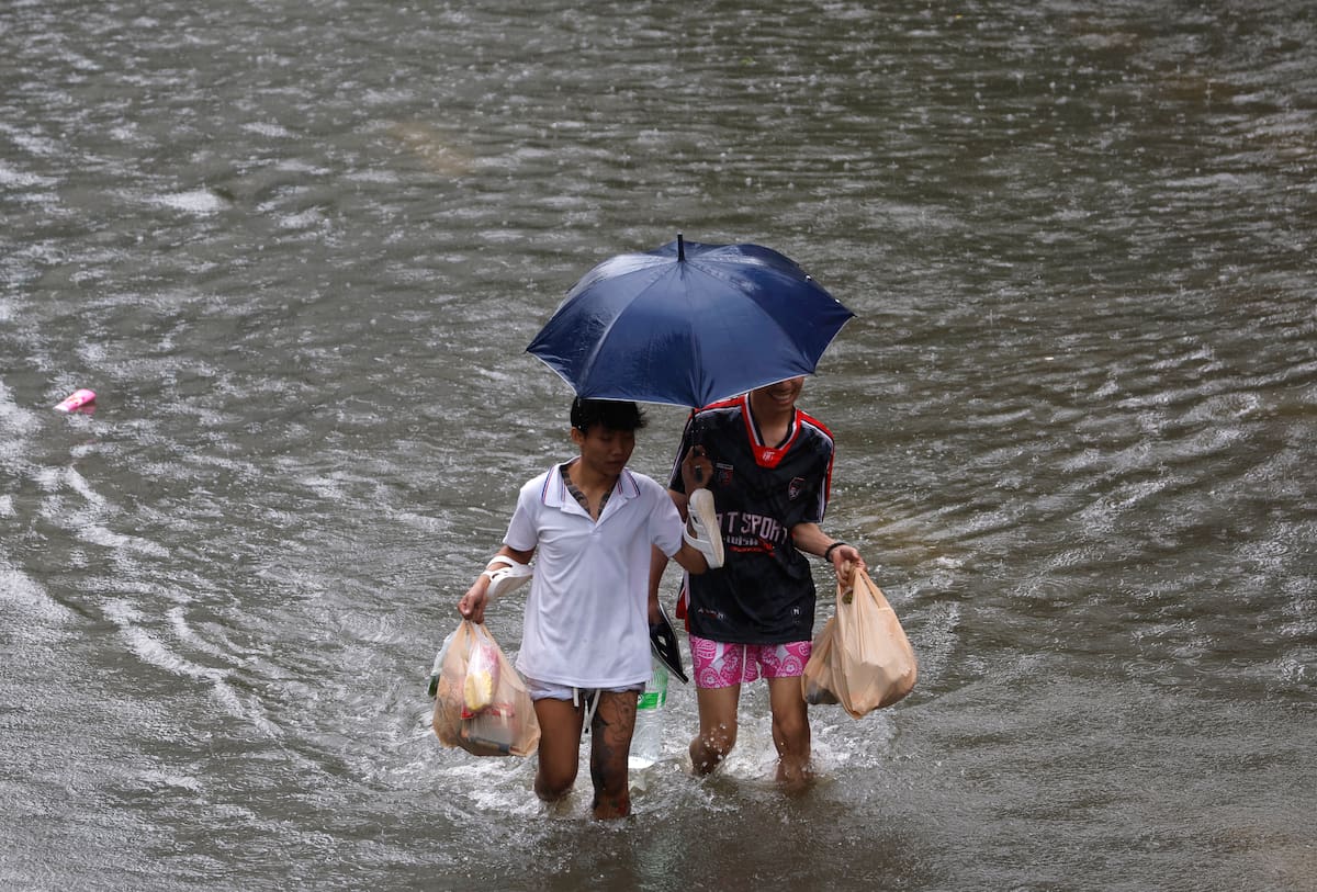 Residentes transportan alimentos mientras caminan entre agua por la calle Petchaburi, una importante arteria de la capital tailandesa, cuyos 50 distritos han sido declarados zonas de desastre por inundaciones tras las intensas y continuas lluvias provocadas por un fuerte sistema de baja presión, sumado a los patrones estacionales del monzón. EFE/EPA/RUNGROJ YONGRIT
