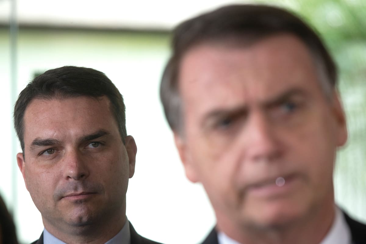 Senador electo Flavio Bolsonaro (i), hijo del expresidente de Brasil, Jair Bolsonaro (d), escucha a su padre durante una rueda de prensa en Brasilia (Brasil). EFE/Joédson Alves