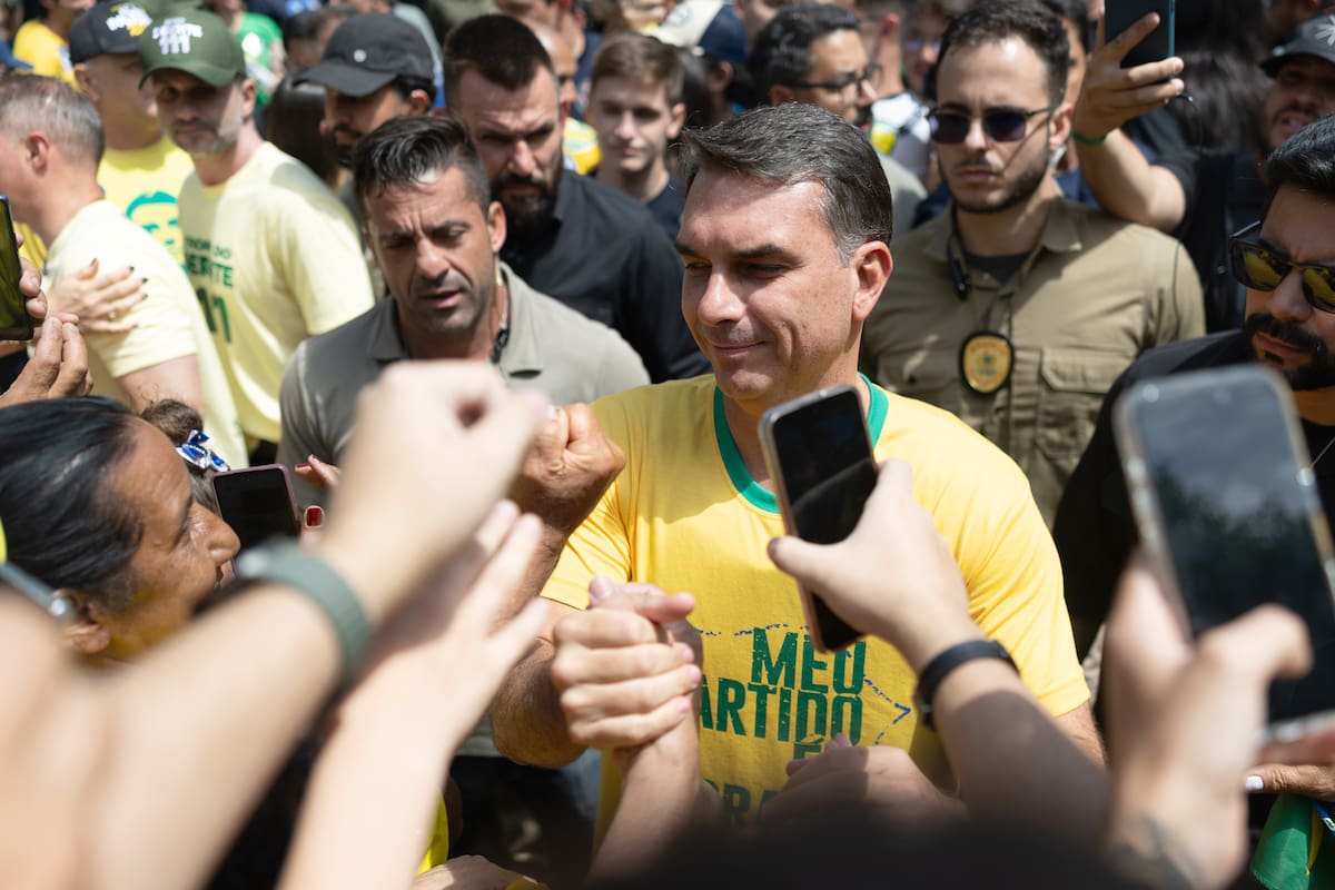 AME2361. SANTA BÁRBARA DOESTE (BRASIL), 03/10/2026.- El candidato a la presidencia de Brasil por el Partido Liberal, Flávio Bolsonaro, posa para una fotografía junto a una simpatizante durante una caravana este sábado, en Santa Bárbara dOeste (Brasil). Más de 158 millones de brasileños están convocados este domingo a las urnas en unas elecciones que no solo decidirán la permanencia de Luiz Inácio Lula da Silva o el ascenso del ultraderechista Flávio Bolsonaro, sino que redefinirán el equilibrio de poder en la región frente a la presión de Washington. EFE/ Isaac Fontana