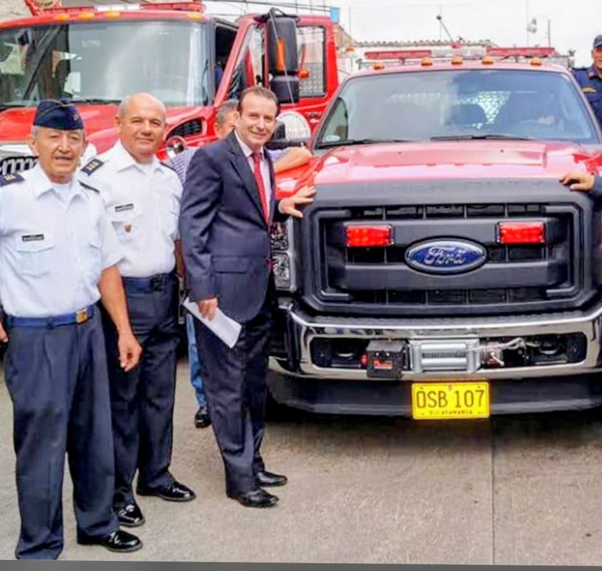 El Capitán Héctor Miguel Ramón, (primero de izquierda a derecha) en una de las ceremonias de entrega de vehículos contra incendios.