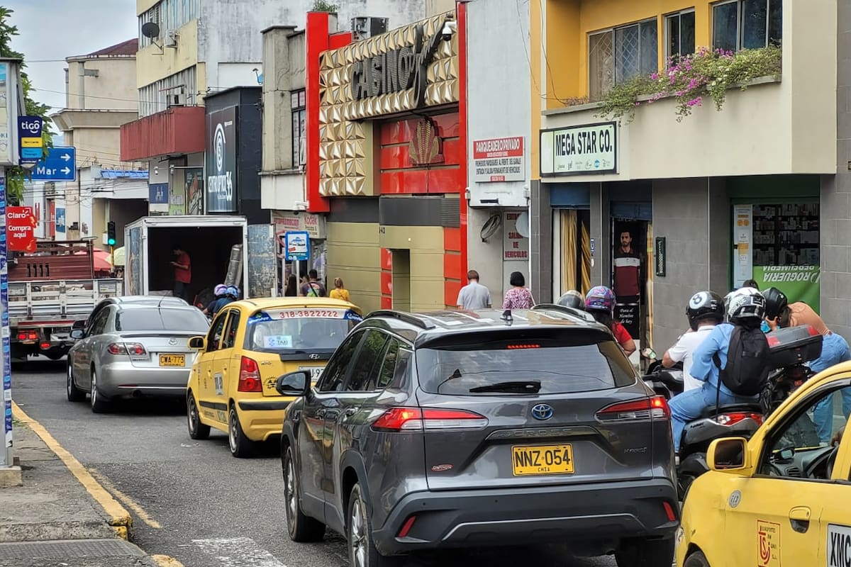 En la calle 36, en el Centro de Bucaramanga, camiones y furgones ocupan parte de la calzada durante las labores de descargue y agravan los trancones. (Foto: Franz Rey / VANGUARDIA)