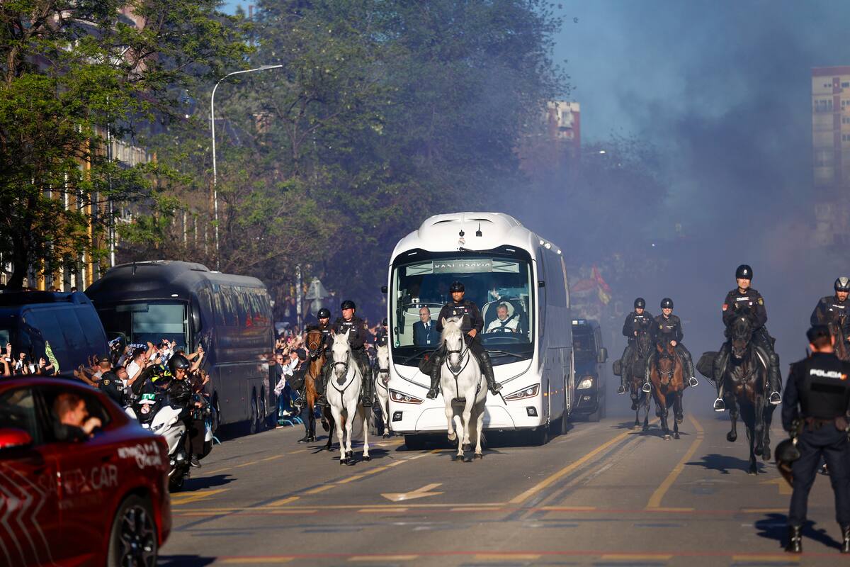 Aficionados del Real Madrid se congregan para recibir al autobús del equipo antes del partido de ida de cuartos de final de la Liga de Campeones.