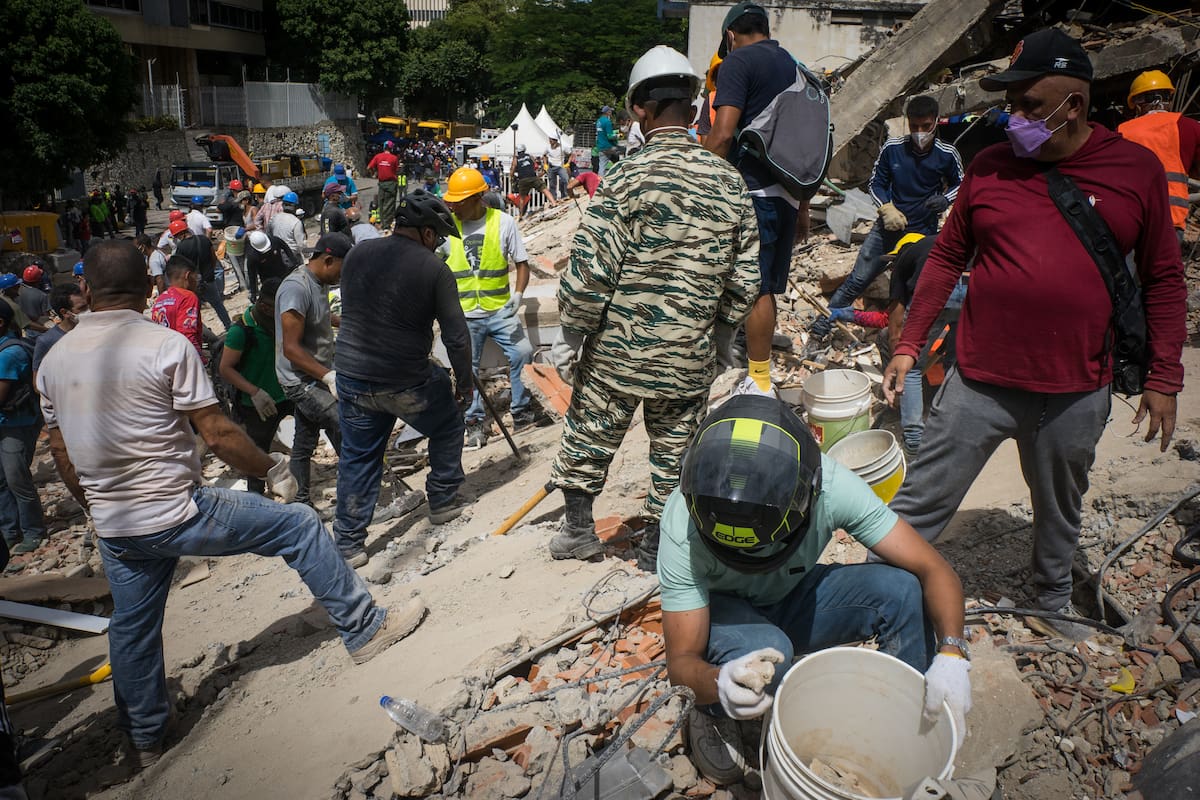 AME4474. CARACAS (VENEZUELA), 25/06/2026.- Rescatistas y voluntarios buscan víctimas en una vivienda afectada por los terremotos este jueves, en el municipio Libertador en el este de Caracas (Venezuela). Los dos terremotos que sacudieron el miércoles la costa norte de Venezuela dejaron al menos 188 fallecidos y más de 1500 heridos. EFE/ Boris Vergara