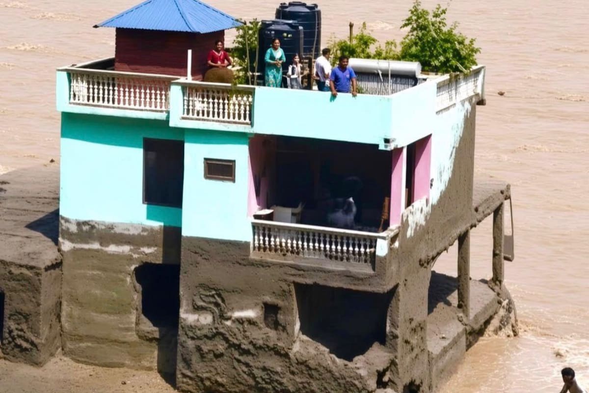 Una familia se refugió en el techo de su vivienda mientras una riada de agua, lodo y escombros rodeaba completamente la casa en Nepal.