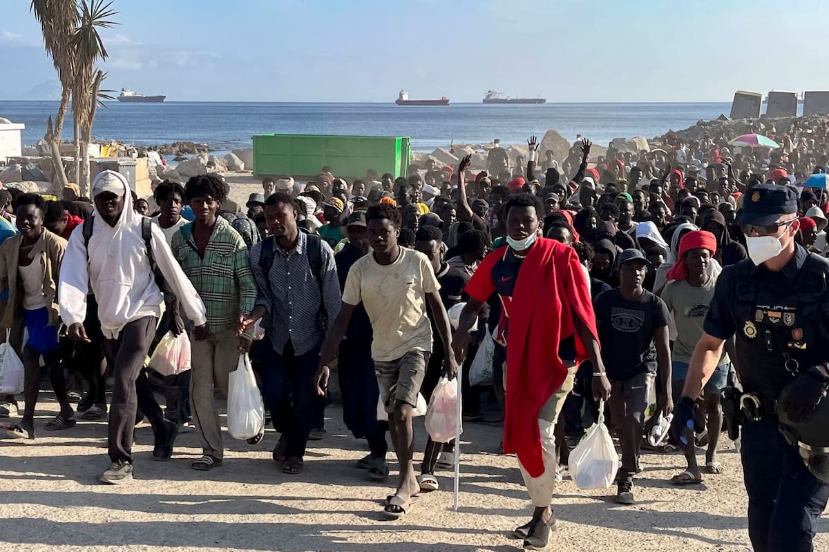 Migrantes desalojados de la playa del Trampolín en Ceuta tras habilitarse un espacio para su acogida. //EFE-Reduan.