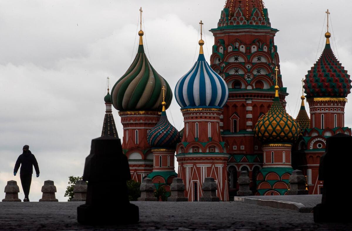 Un hombre camina frente a la catedral de Vasily the Blessed en la desierta Plaza Roja durante el encierro, en un esfuerzo por combatir la propagación del coronavirus SARS-CoV-2, en el centro de Moscú, Rusia. (Foto EFE / VANGUARDIA)