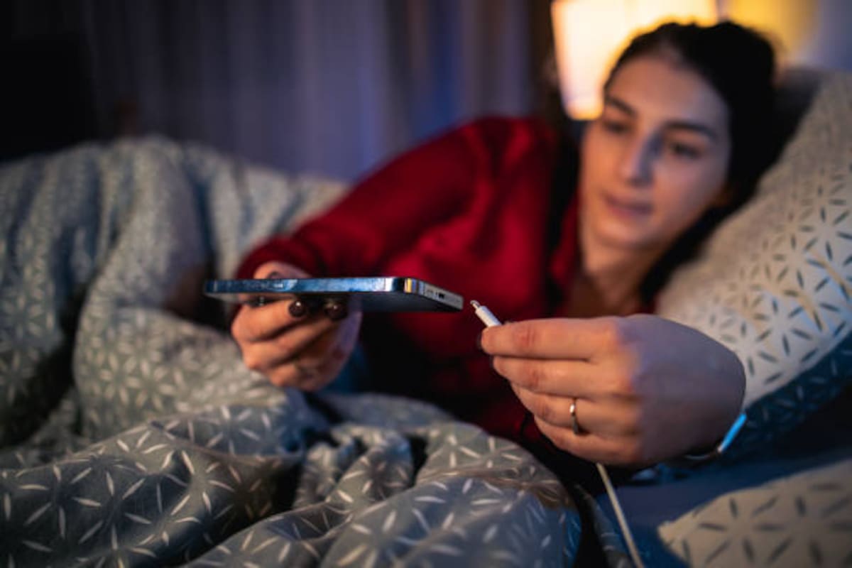 Una joven cargando el celular.