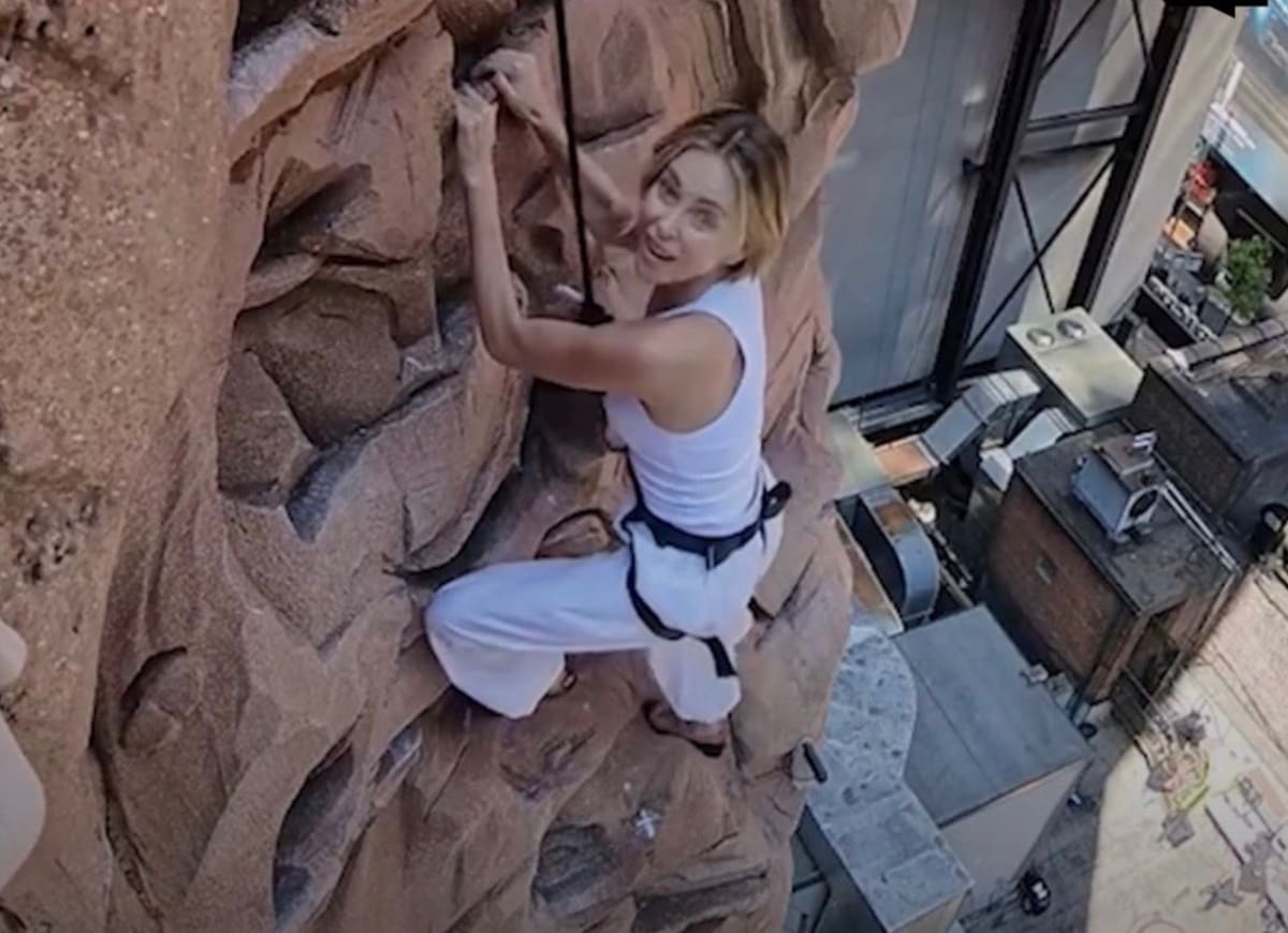 Charlize Theron escala hasta la cima de un cartel en Times Square para promocionar su nueva película de Netflix, 'Apex'.
